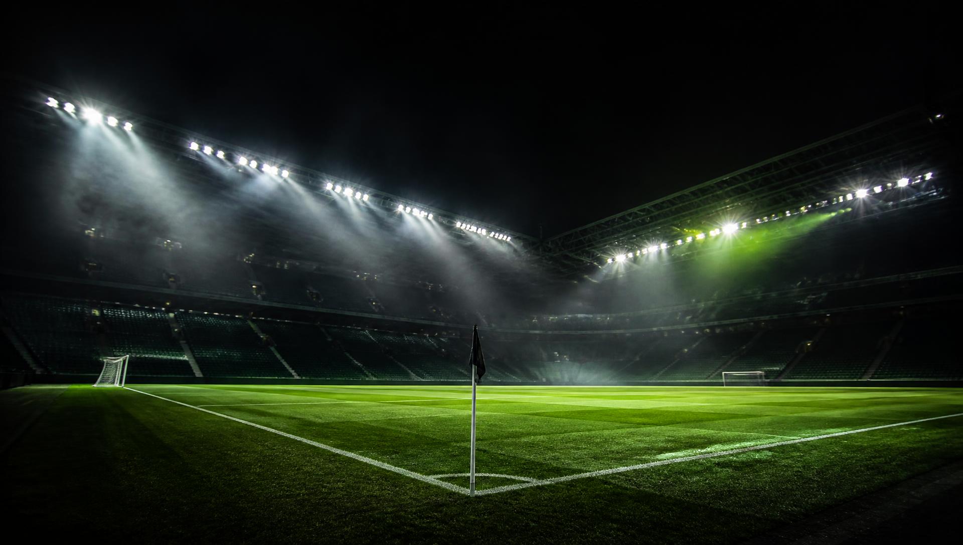 Floodlit football stadium at night